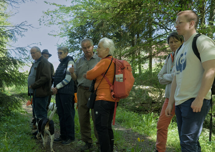 Eine Gruppe von sieben Personen lauscht den Erzählungen des Eventleiters Fritz, zum Thema Feldhasen