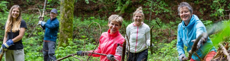 Fünf fleissige Helfer schichten Äste zu einem grossen Asthaufen zusammen.