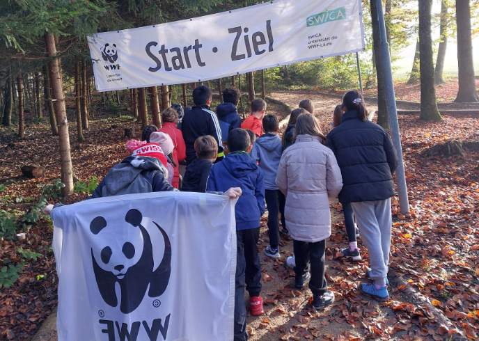Die Schulklasse steht unter dem Start- und Zielbanner beim Rehwald in Flawil.