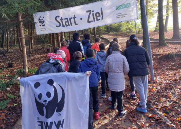 Die Schulklasse steht unter dem Start- und Zielbanner beim Rehwald in Flawil.